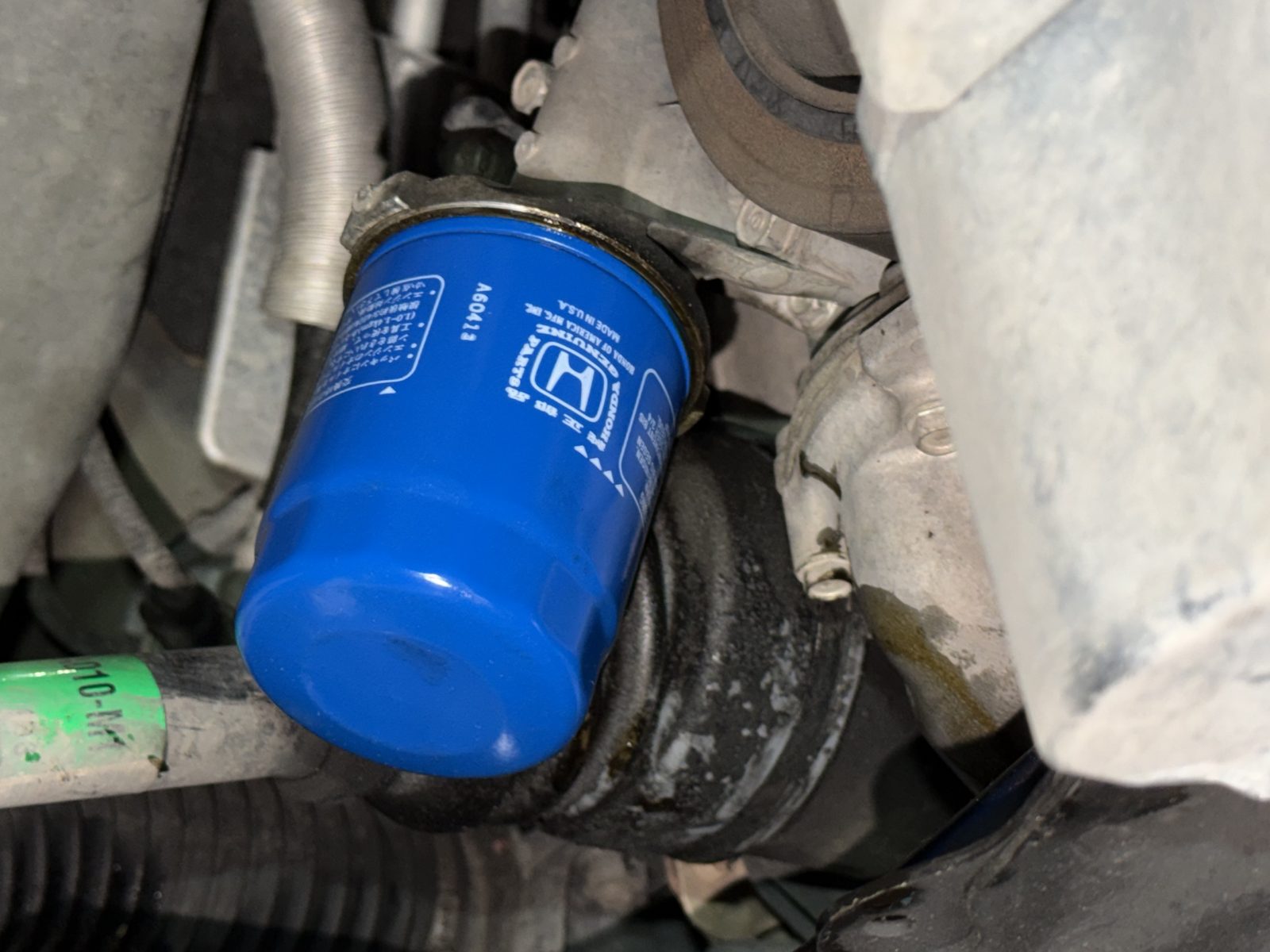New Honda Genuine oil filter being installed during an oil change at Action Automotive in Colorado Springs