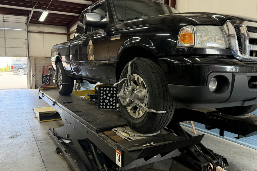 Pickup truck on the wheel alignment rack inside the Action Automotive shop in Colorado Springs